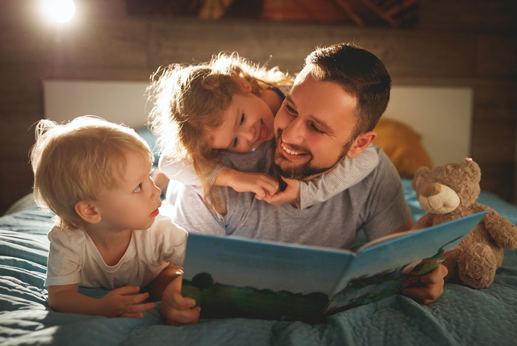 evening family reading. father reads children a book before going to bed