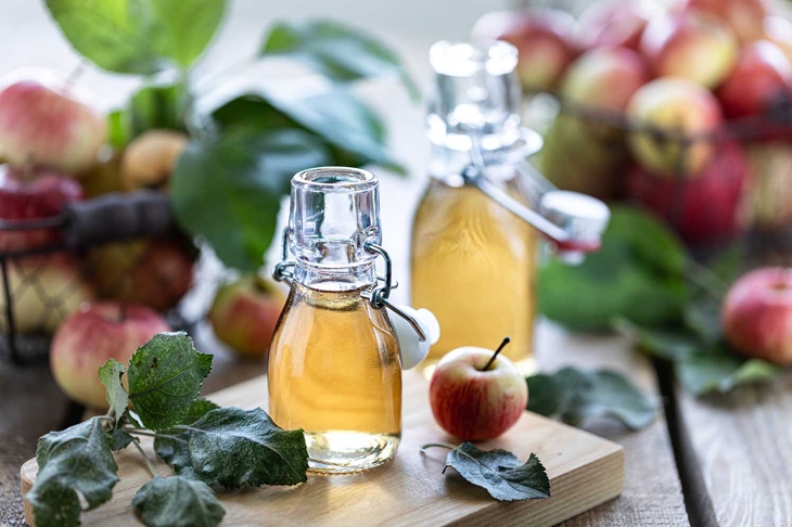 Apple vinegar. Bottle of apple organic vinegar or cider on wooden background. Healthy organic food