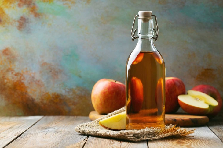 Apple vinegar. Bottle of apple organic vinegar or cider on wooden background. Healthy organic food. With copy space